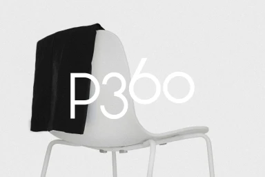 White molded plastic chair with a black jacket draped over the back against a textured light grey background