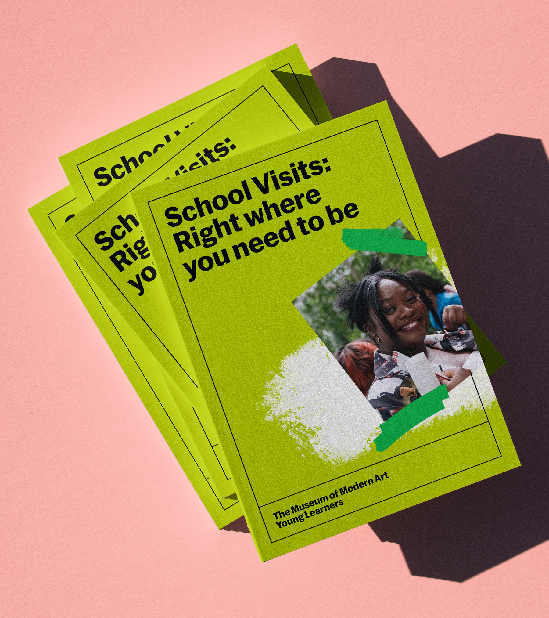 School visit advertisement featuring a student smiling, surrounded by lime green flyers on a light pink surface with a shadow.