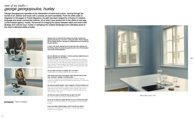 Bright architectural shot of a light blue room with windows and a table holding glasses, a laptop, and other objects in a serene setting.