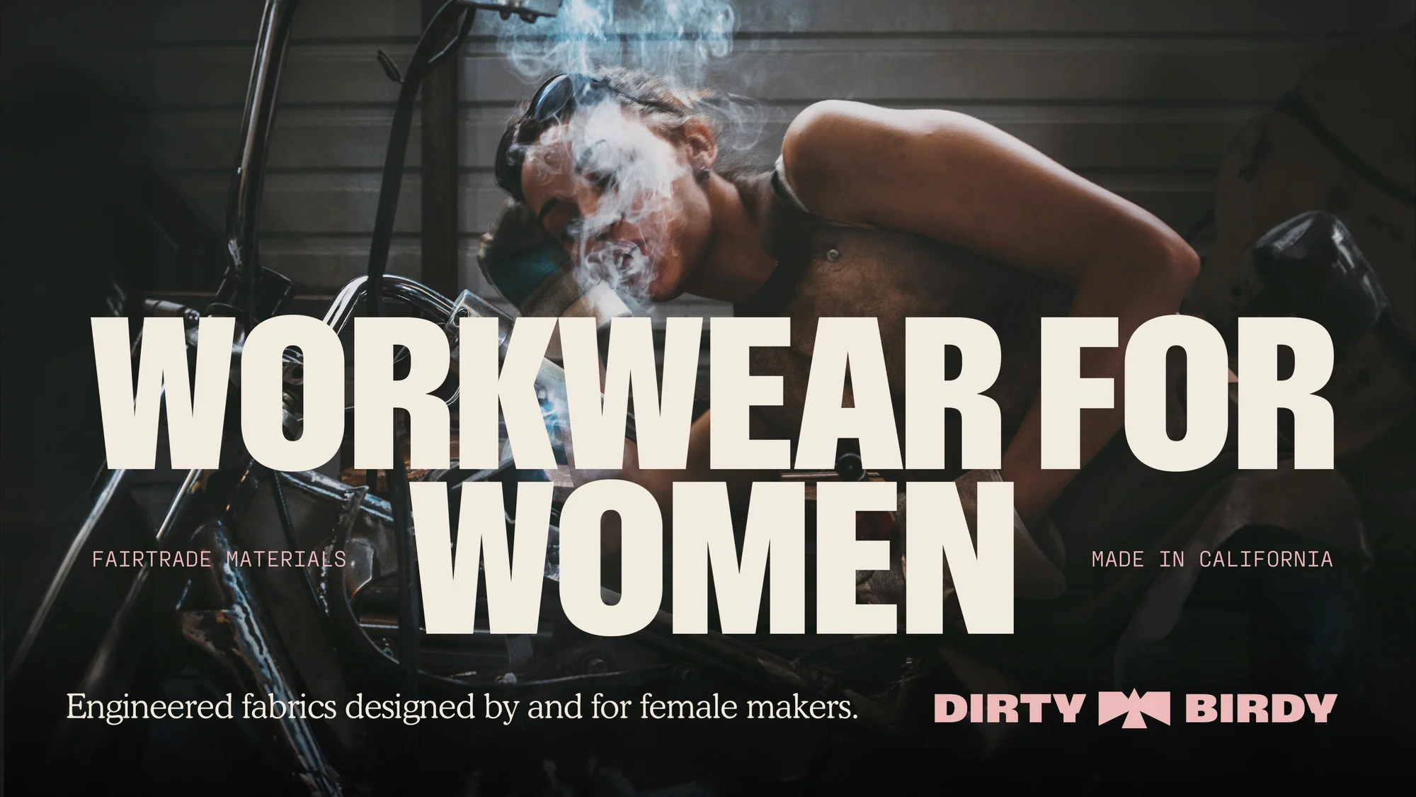 Woman wearing safety glasses welds in a workshop, creating workwear, with a brand logo and text overlay. Made in California.