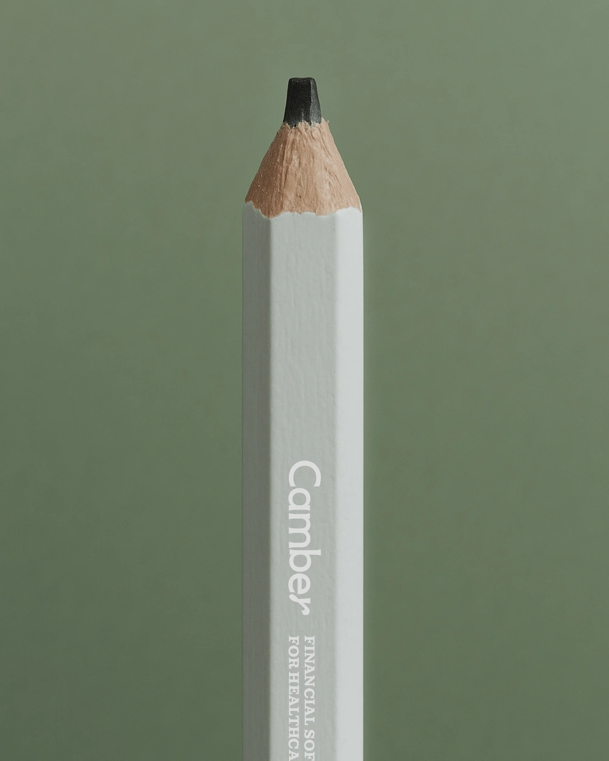 Close-up studio shot of a white square pencil with a black tip against an olive green background, featuring financial software text.