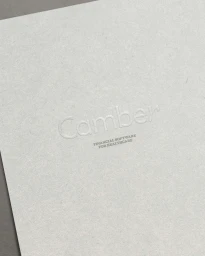 Embossed Camber brand logo on textured grey paper surface with Financial Software for Healthcare text below