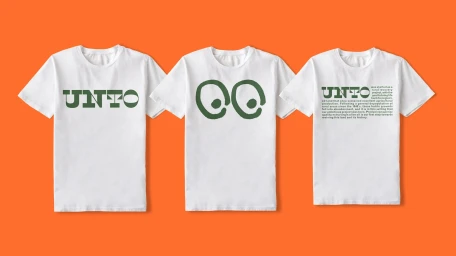 Three white t-shirts featuring green graphic typography and illustrations laid out flat against a vibrant orange background.