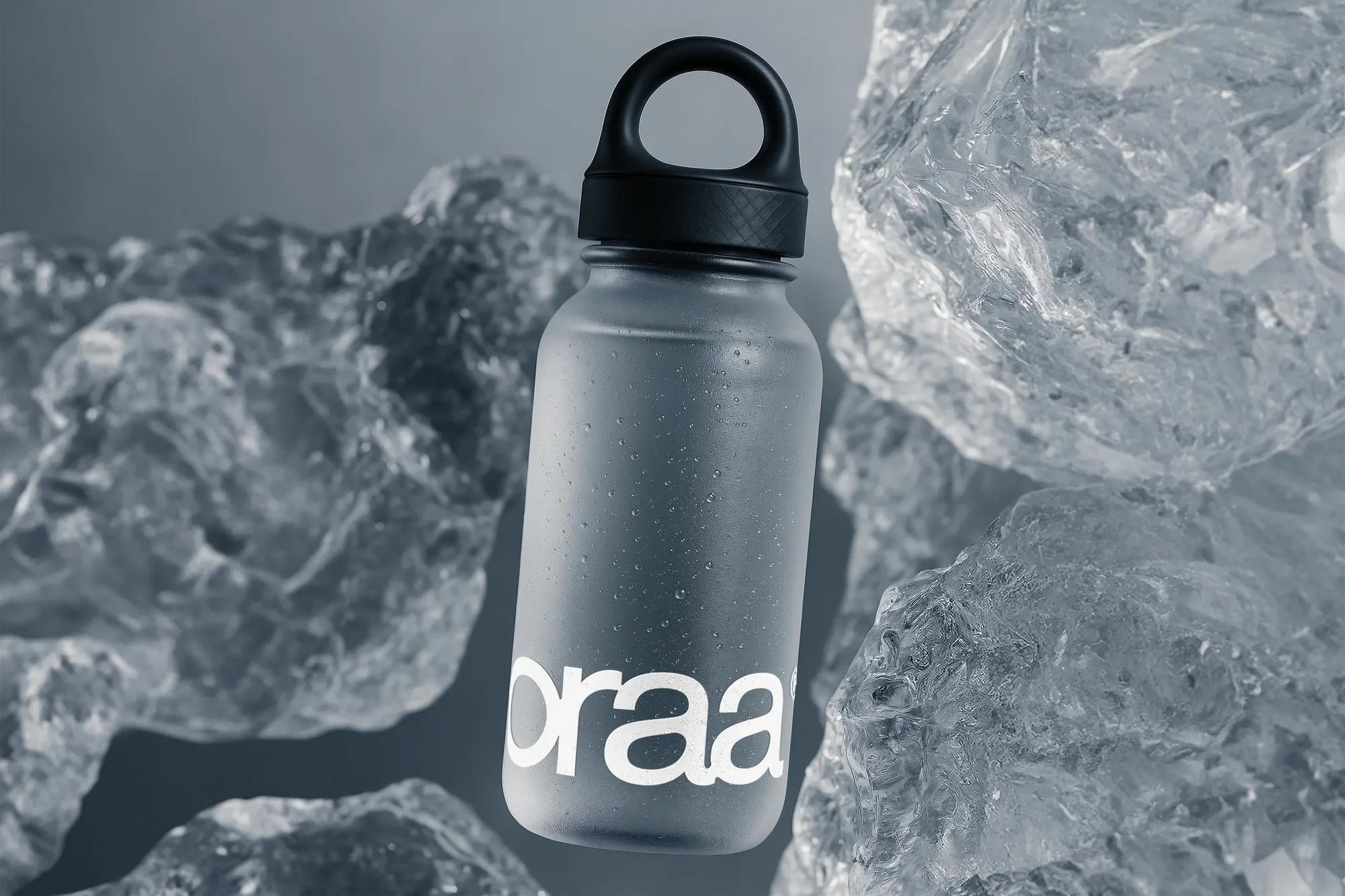 Icy still life of a water bottle surrounded by ice chunks. Bottle is condensated, with the text 'oraa' on the side.