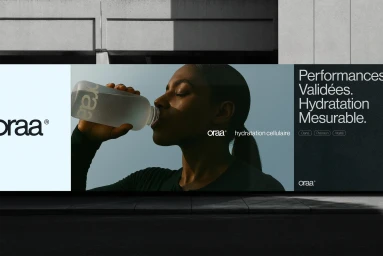 Billboard advertising Oraa featuring a Black woman drinking from a frosted glass water bottle against a concrete exterior