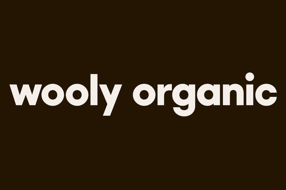 Wooly Organic brand logo with bold white text on a dark brown background, simple and clean design.
