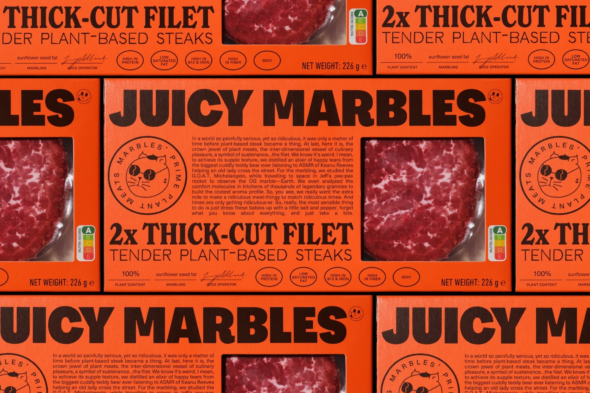 Stacks of vibrant orange Juicy Marbles plant-based steak packaging, prominently featuring product names and enticing imagery of the steaks.