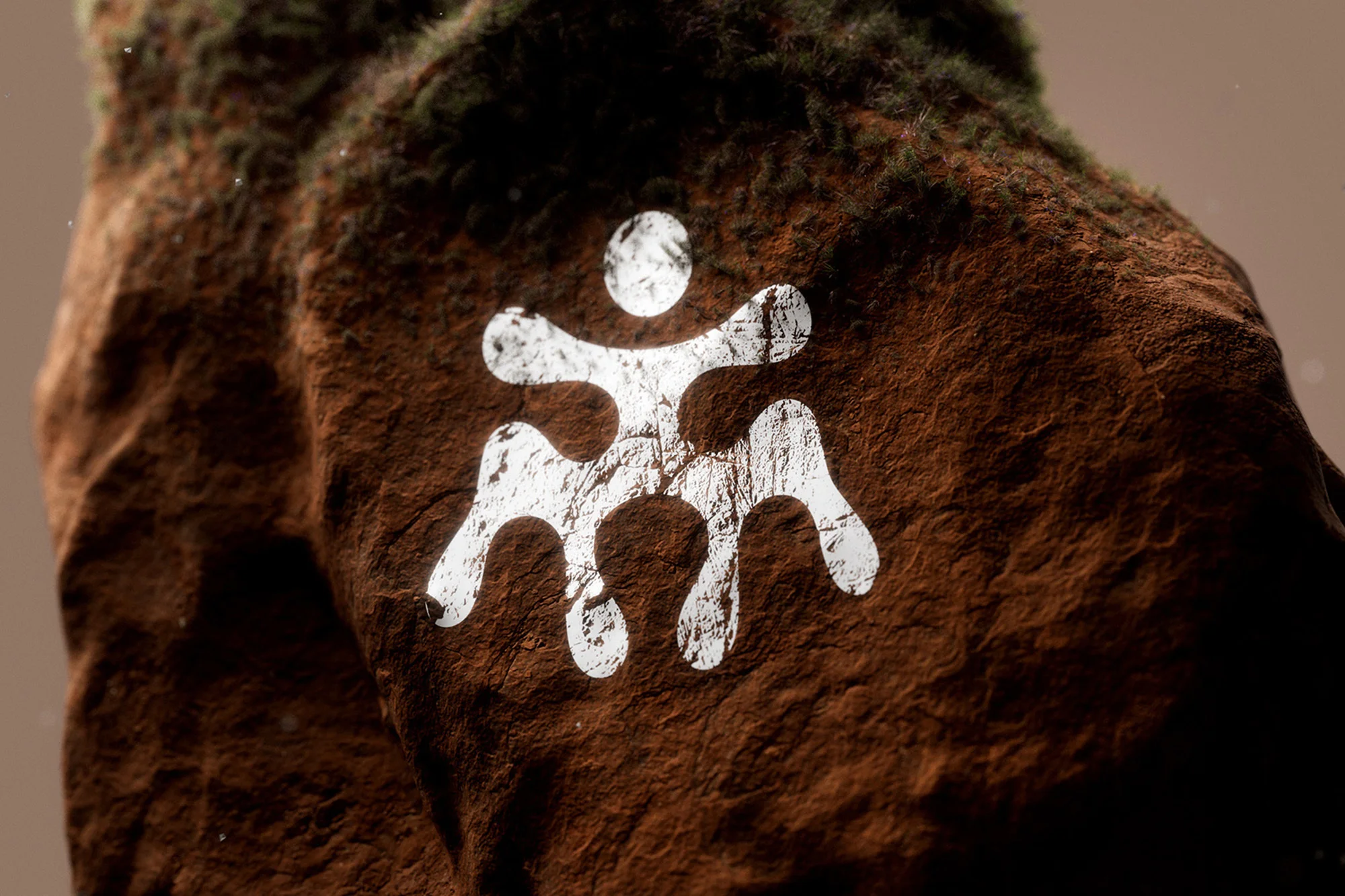 A close-up of a textured brown rock surface featuring a white graphic symbol, set against a muted earth-toned background.