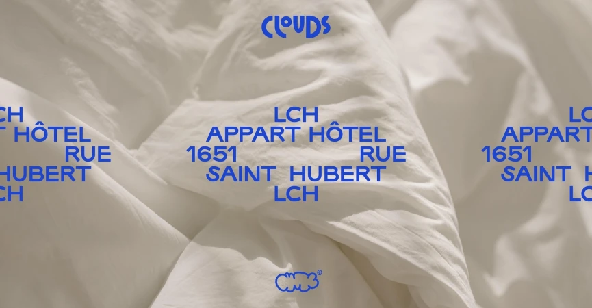 White duvet cover with blue text overlay reads Clouds, LCH Appart Hotel, and Saint Hubert, creating a modern, minimalist design.