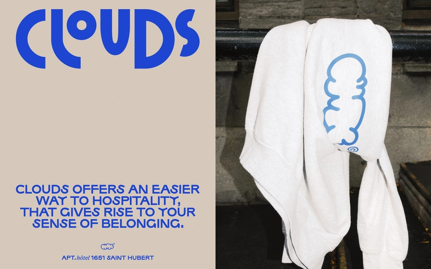 White hoodie draped over a dark metal railing next to a beige panel featuring bold blue typography for Hotel Clouds.