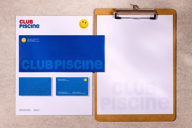 Stationery set featuring Club Piscine branding with a letterhead, envelope, business cards, and a clipboard on a textured background.
