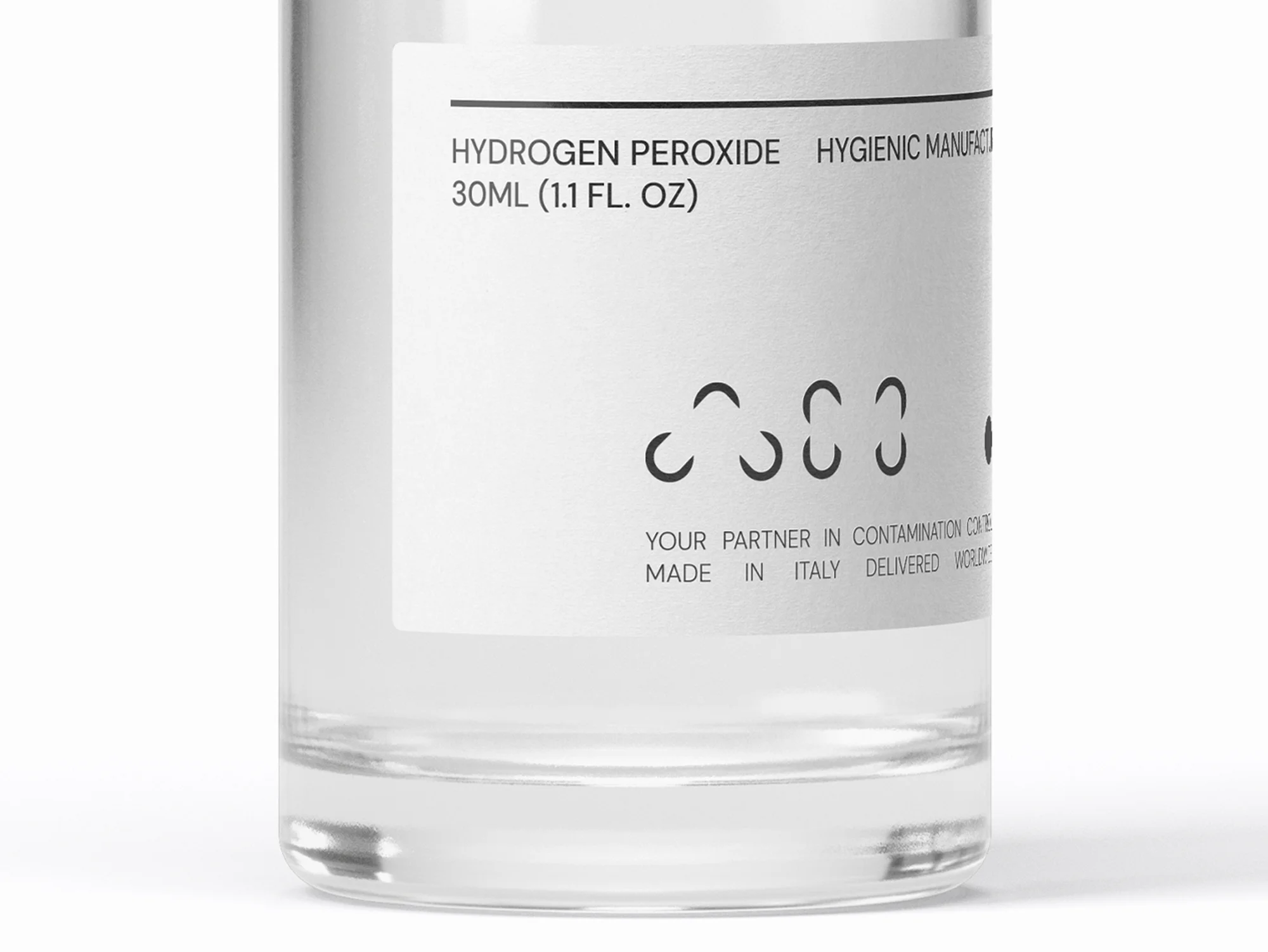 Close-up studio shot of a clear bottle with a white label, featuring the words HYDROGEN PEROXIDE and other product information.