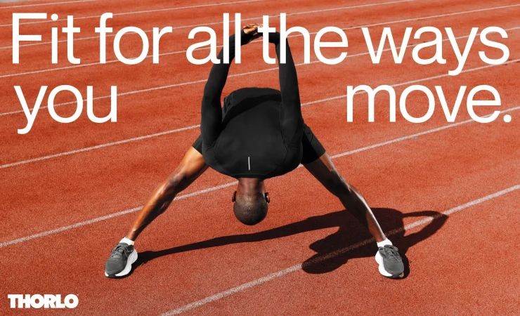 Black athletic wear showcased on African-American male stretching on a red running track with white lanes, promoting fitness and movement.
