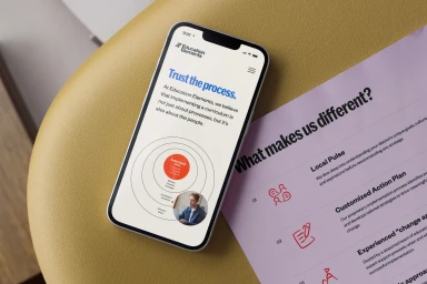 Smartphone displaying a digital interface and printed document layout resting on a yellow surface