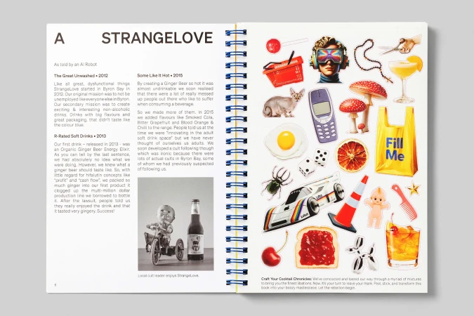 Opened notebook with lifestyle sticker collage. Colorful objects include drinks, sunglasses, phone, car, and mushrooms on white paper.