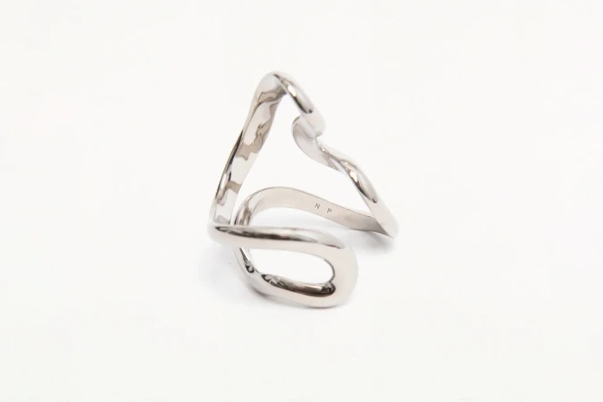 Abstract silver metal ring on a white background, showcasing its fluid, modern design and reflective surface in a close-up shot.