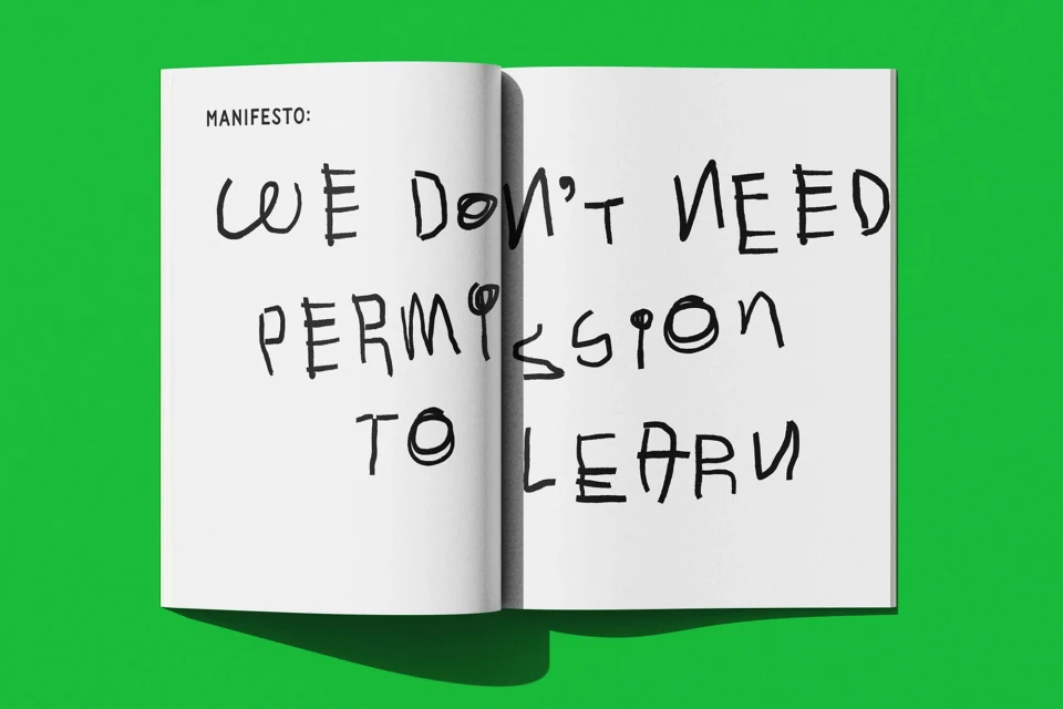Open book on a vibrant green background displays a handwritten manifesto: 'We don't need permission to learn' in bold black letters.