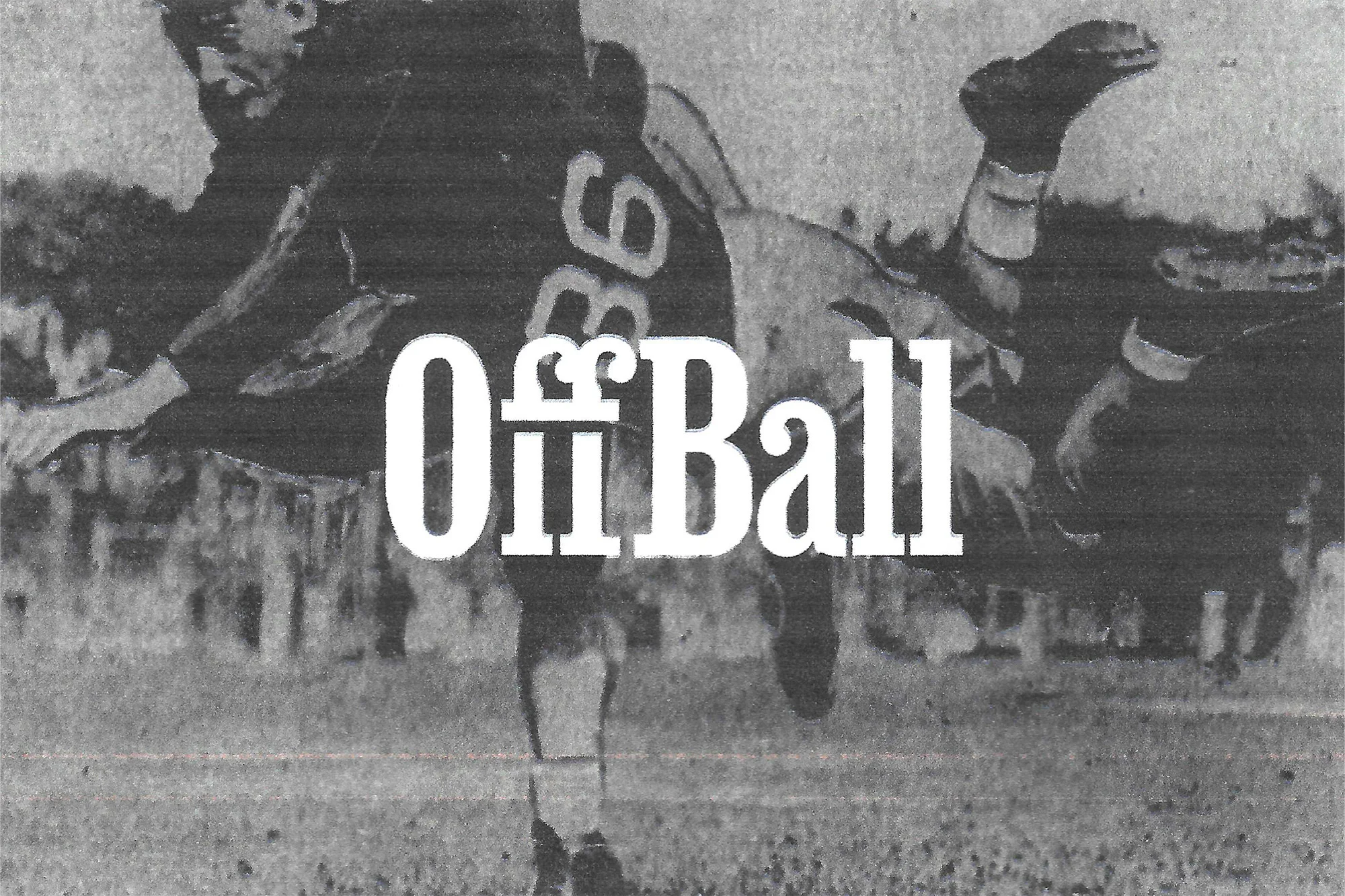 Monochrome action shot of American football players tackling each other on a grassy field, captured in a vintage style.