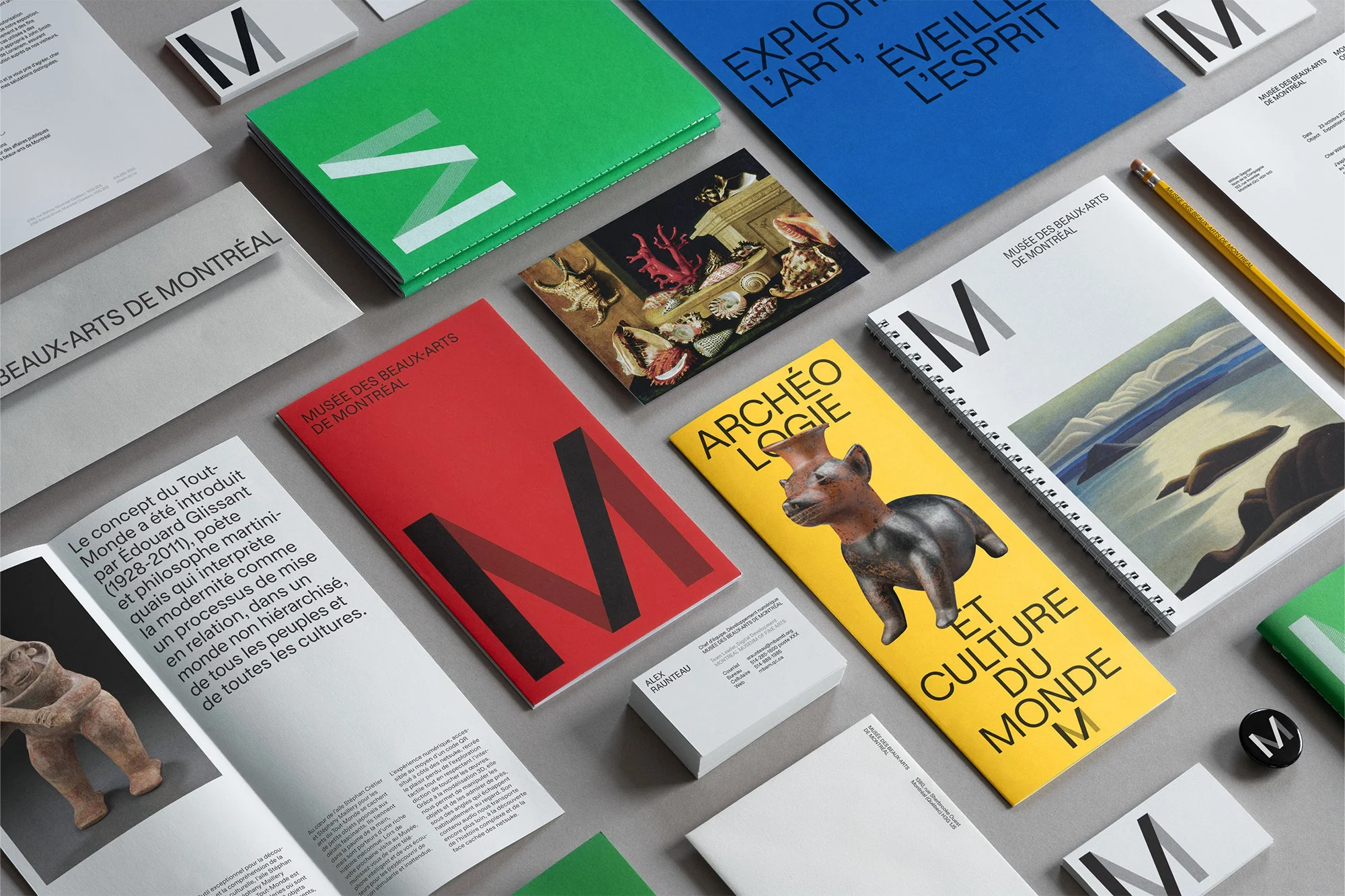Promotional flat lay featuring Montreal Museum of Fine Arts brochures and stationery in green, red, yellow, and blue with the letter M.