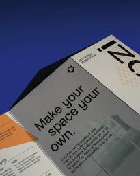 Close-up angled shot of a branded Decozi brochure featuring bold typography on a light gray page against a rich blue background