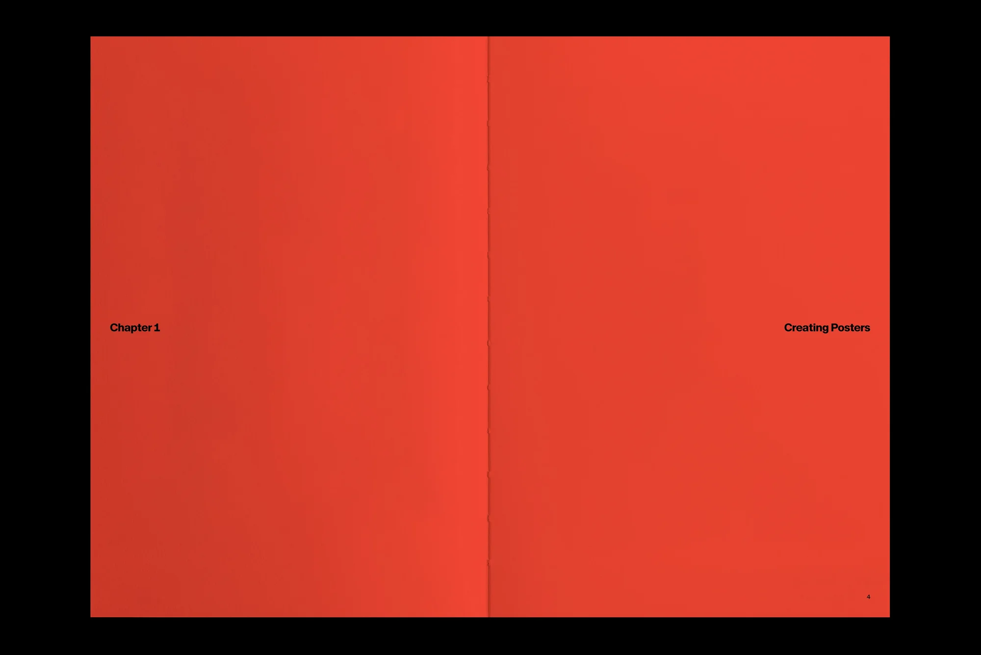 Open book with red pages and black text reading 'Chapter 1' and 'Creating Posters' against a black background.