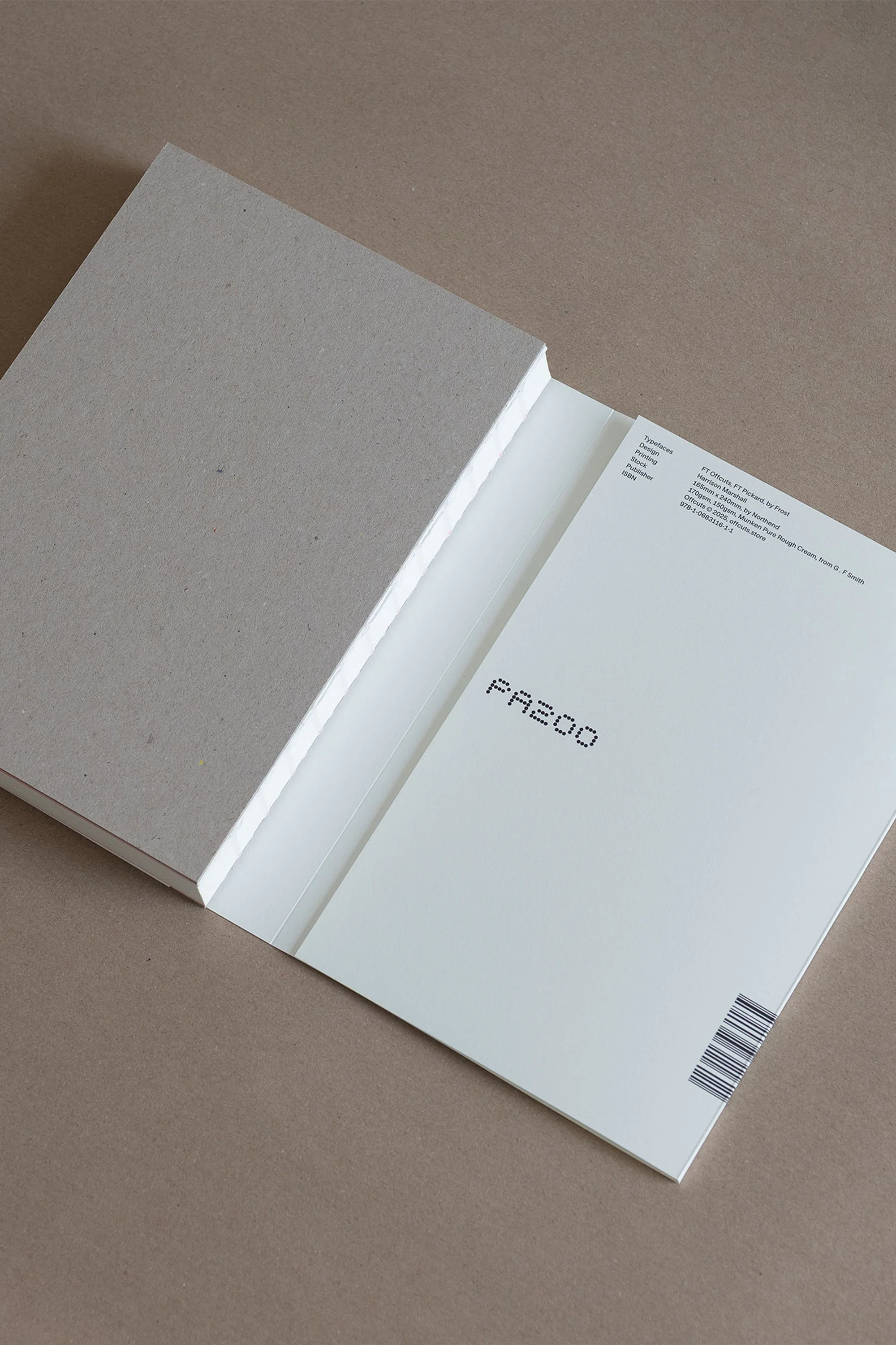 Stack of white paper sheets with gray hardcover folder on tan background, shot in portrait orientation and medium framing.