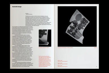 Spreading open pages of a design publication showing editorial layout, typography columns, and graphic posters against a black background.