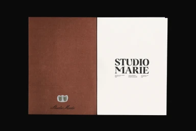 Open brochure displaying a solid brown cover page and a white title page featuring the Studio Marie wordmark.
