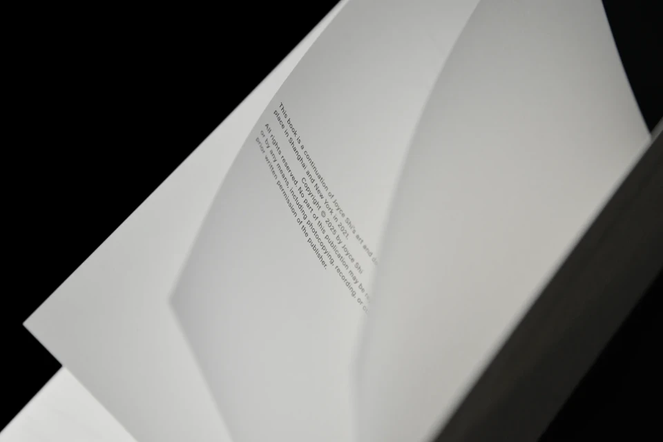 Open book with copyright information in English, including the year and publisher's rights, against a black background. Close-up view.