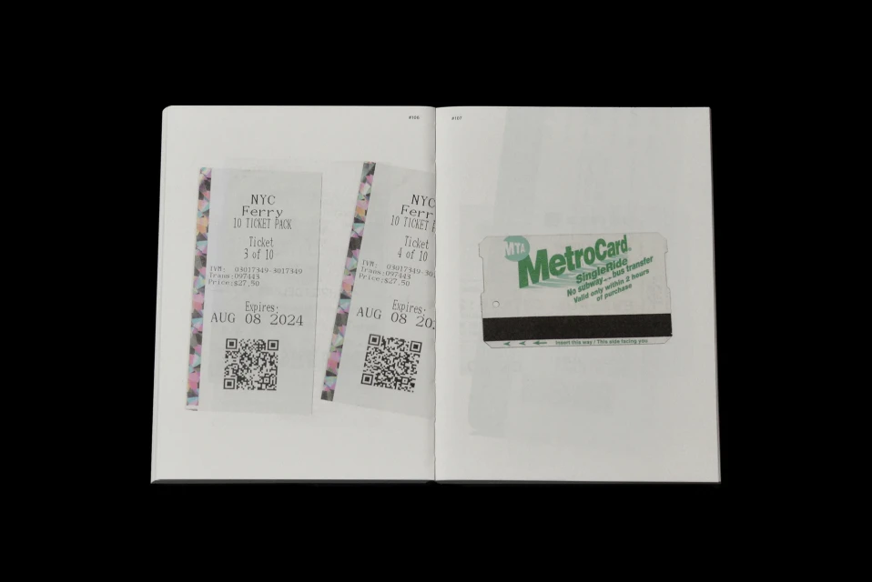 Open book pages featuring two NYC ferry tickets and a MetroCard, all displayed against a plain black background in a studio setting.