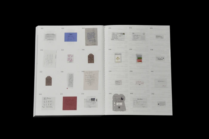 An open book displaying a grid layout of small archival items, letters, and ephemera on printed pages against a black background.