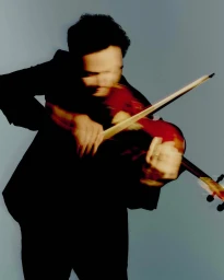 Musician playing a violin with motion blur against a grey studio backdrop, captured for Omega Ensemble's 2025 National Concert Season.