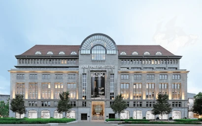 Exterior facade of the KaDeWe department store building with symmetrical architectural windows, arched top, and prominent central banner.