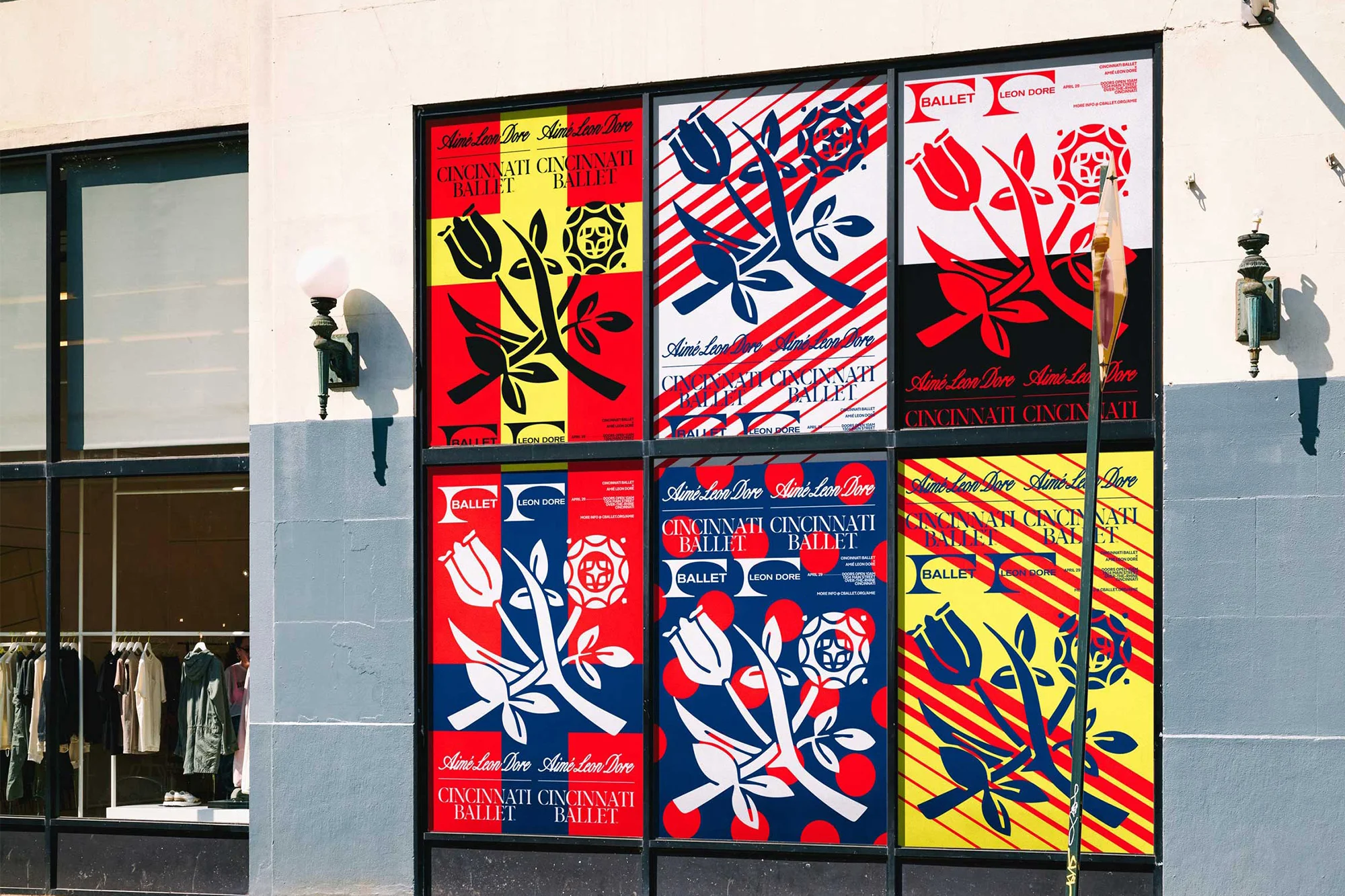 Exterior view of Cincinnati Ballet posters in window. The posters feature a tulip and geometric shapes in blue, red, yellow, and black colors.