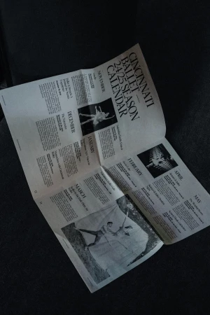 Cincinnati Ballet 24/25 season calendar featuring dancers in performance photos and event dates, on a textured surface.