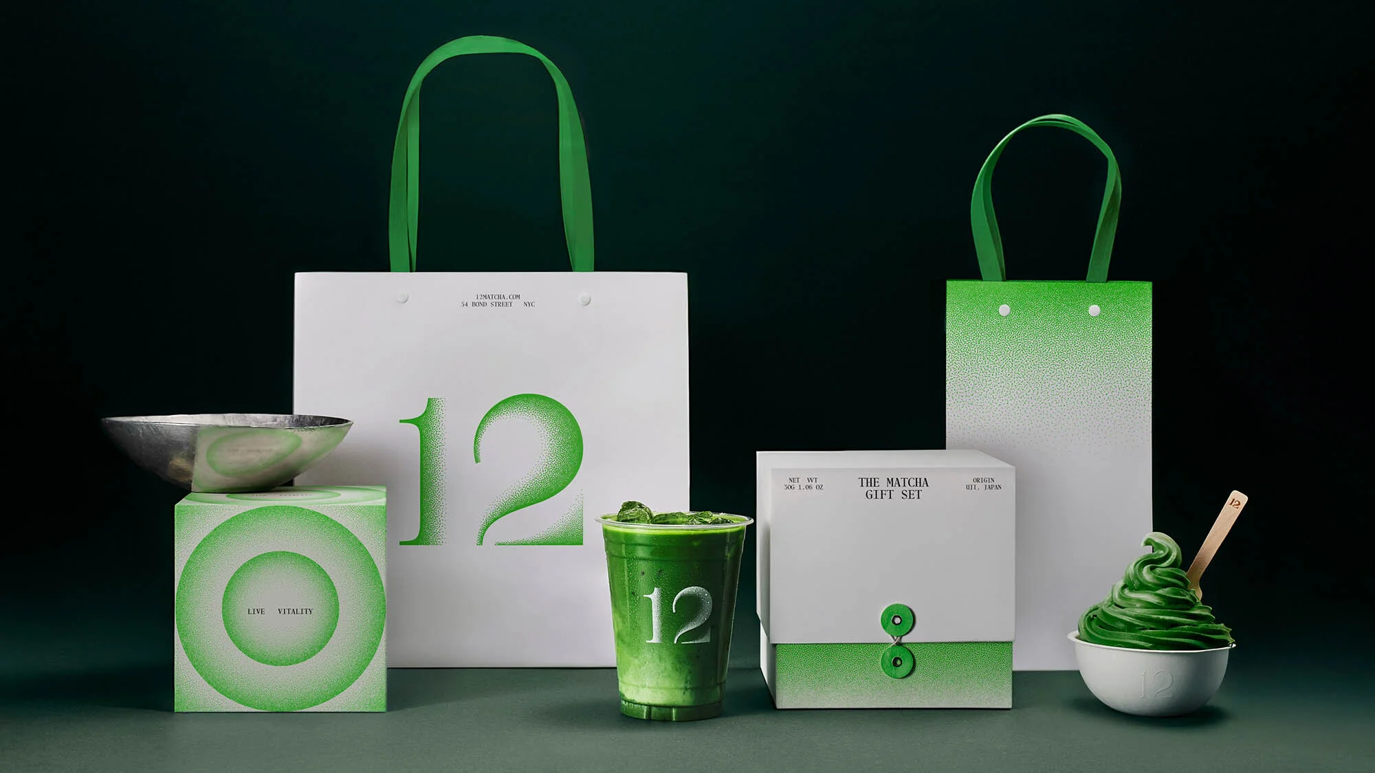 Matcha drink, soft serve, and gift set packaging displayed with matching white and green color scheme on a dark green surface.