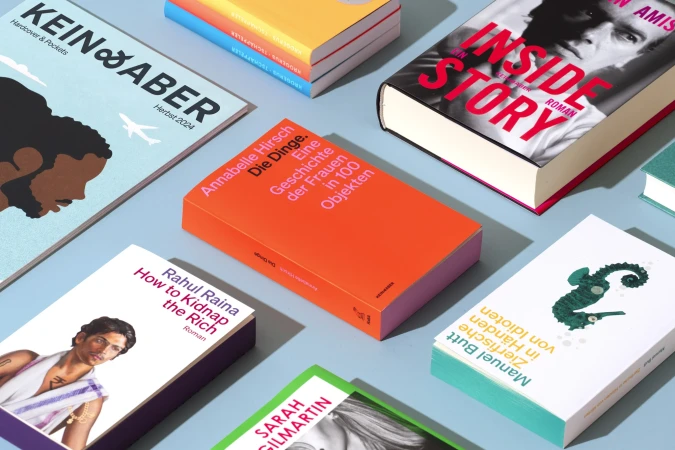 Colorful book covers and a magazine arranged on a blue surface, featuring various titles and designs. Flat lay.