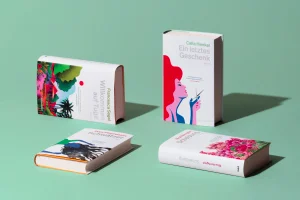 Four hardcover books with colourful illustrated covers arranged on a mint green surface with distinct shadows.