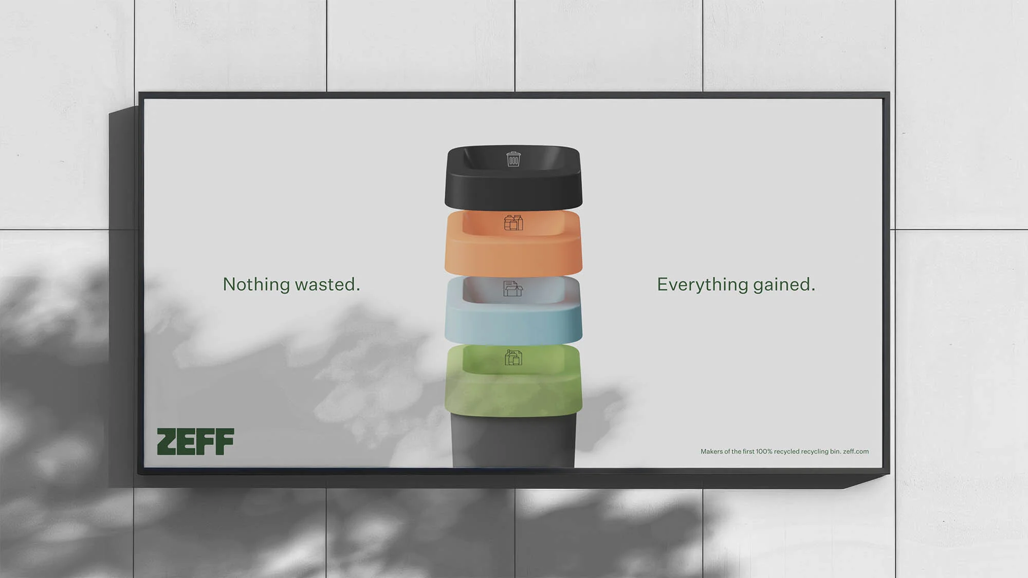Conceptual advertisement for a recycling company featuring stacked recycling bins on a poster against a textured grey wall with light shadows.