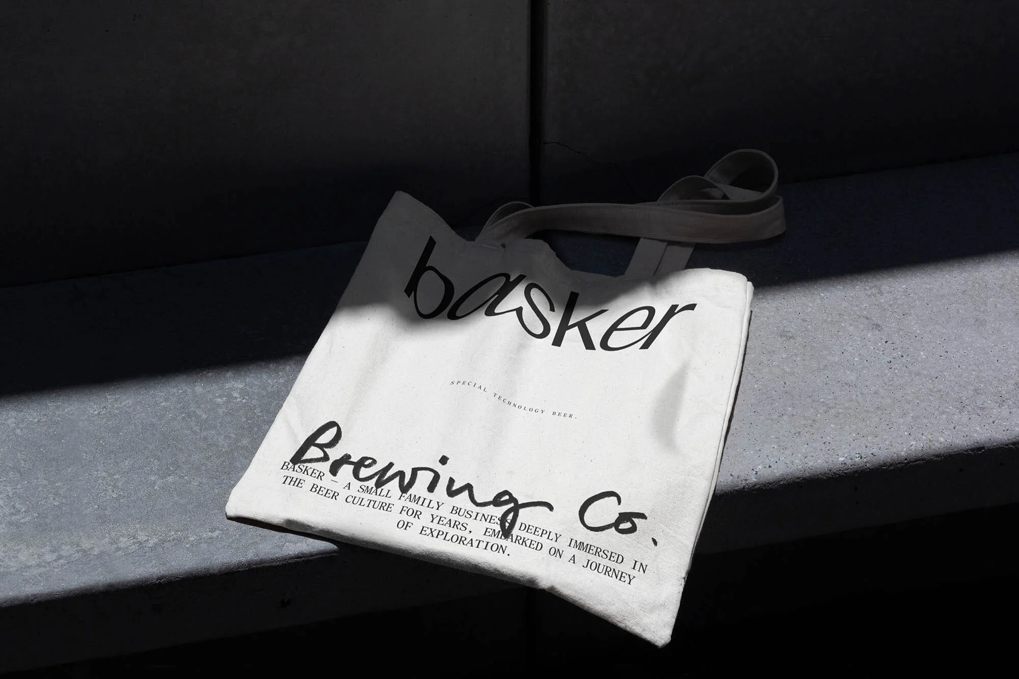 Canvas tote bag with 'basker Brewing Co.' text, branding for a small family business deeply immersed in beer culture on grey surface.