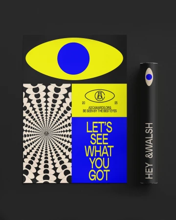 Abstract graphic design featuring a yellow eye, radial pattern, and typography on a black background in a studio setting.