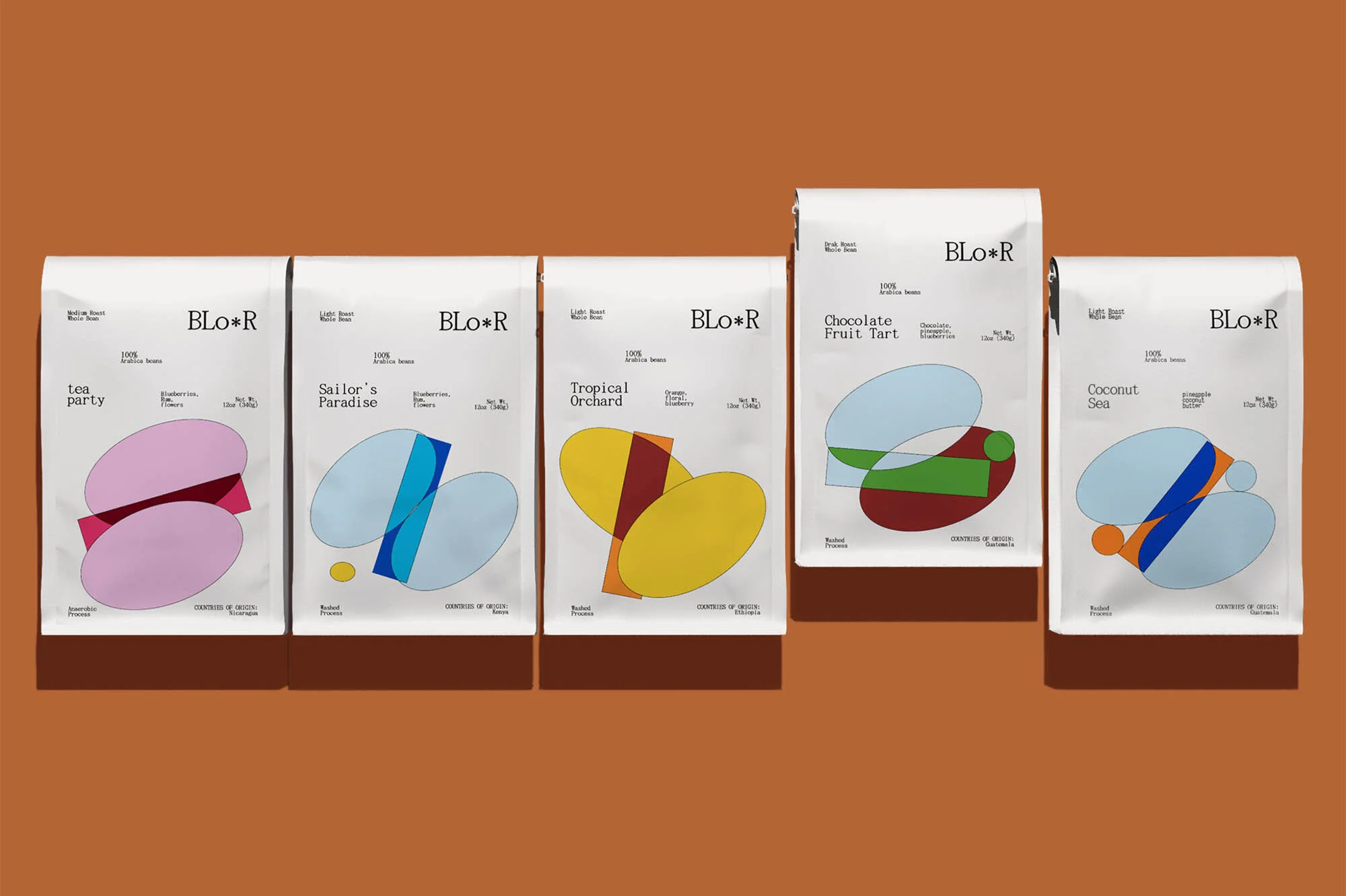 Five BLO*R coffee bags with unique, colorful geometric designs on a brown background, arranged in a horizontal still-life shot. Packaging design.