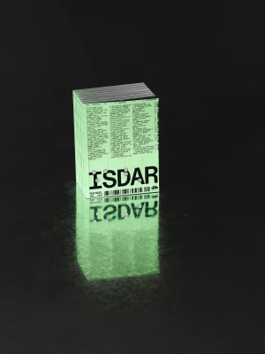 Stack of light green printed booklets with ISDAR typography resting on a dark reflective surface