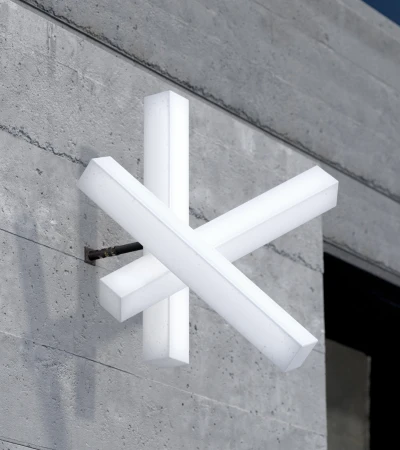Modern abstract art installation featuring illuminated rectangular blocks mounted on a textured concrete wall, contemporary design.