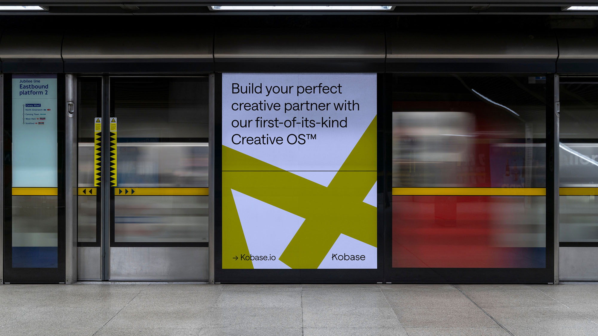 Subway station advertising Kobase's Creative OS, featuring a modern design with geometric shapes and bold typography on train doors.