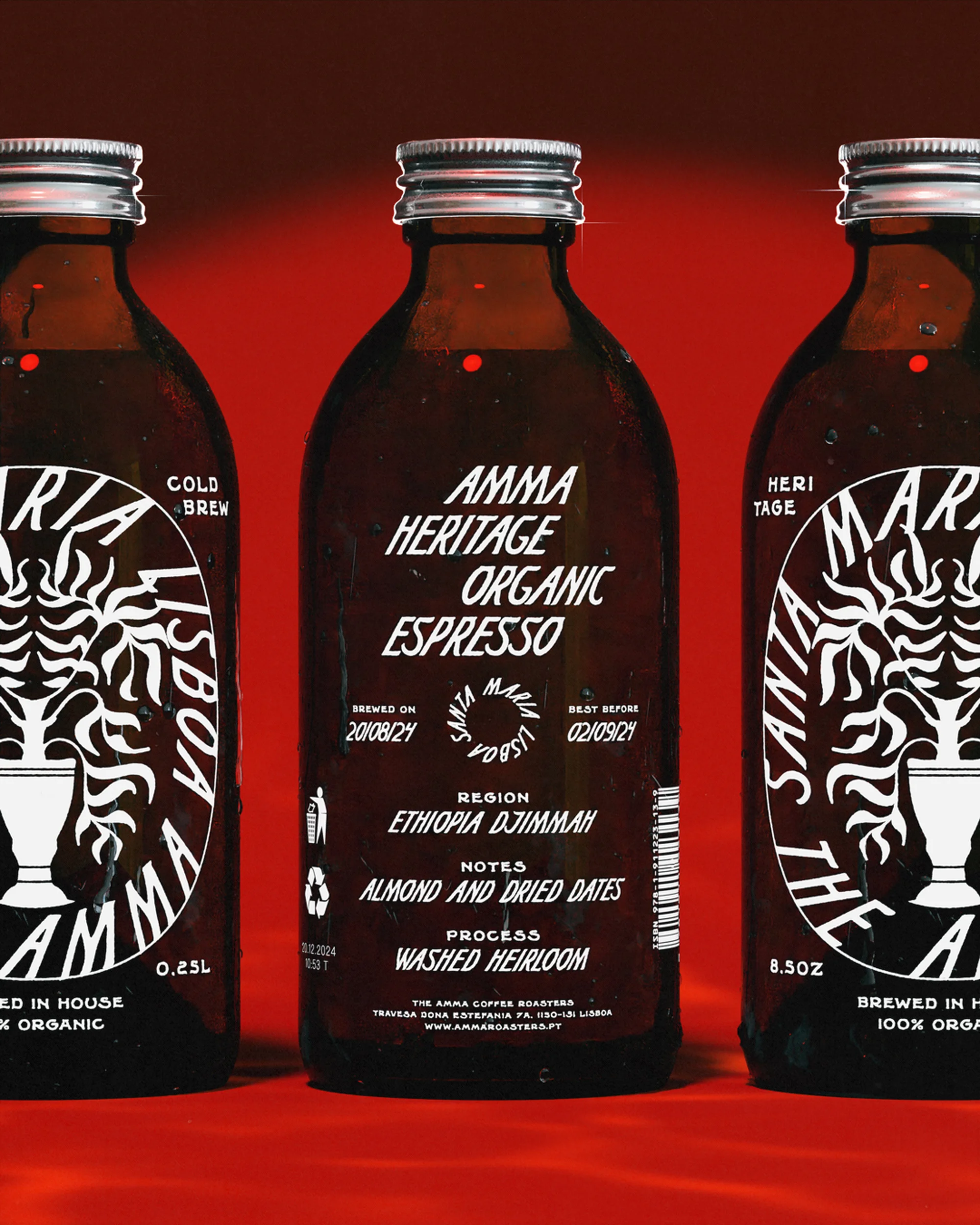 Three amber glass bottles of Amma Heritage Organic Espresso are arranged on a red surface, featuring vintage-style white labeling.