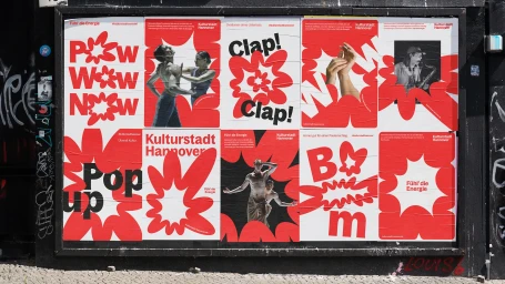 Posters pasted on a dark street wall showcasing the Hanover brand identity with bold red graphic starburst shapes and typography.