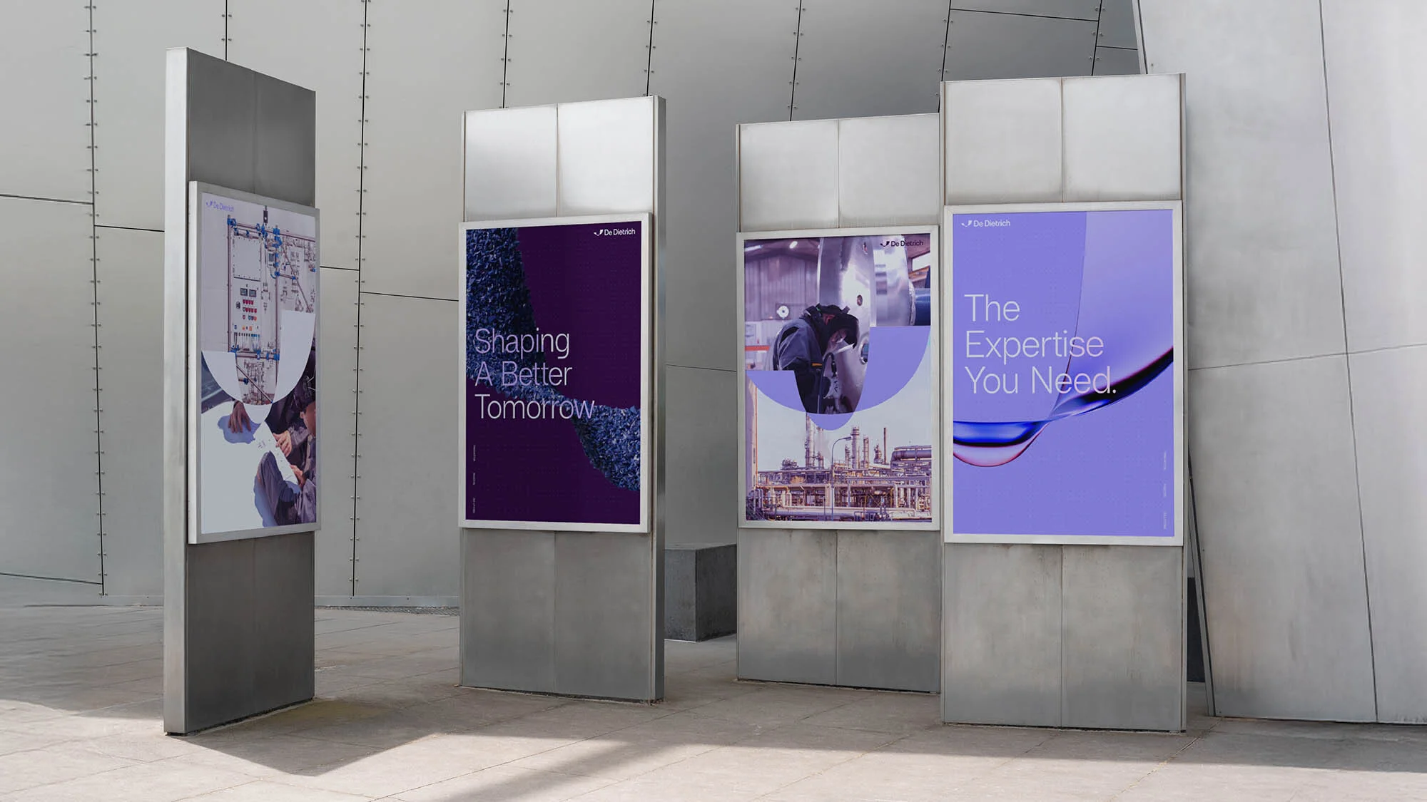 Four industrial advertisements by De Dietrich are displayed on posts, featuring manufacturing scenes and corporate slogans in an urban setting.