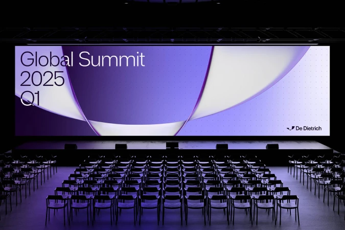View of an empty auditorium with chairs and a large screen displaying "Global Summit 2025 Q1" and the logo of De Dietrich.