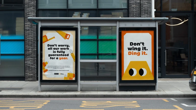 Bus stop advertisement featuring an advertisement guaranteeing work and another advertisement with cartoon eyes on an orange background.